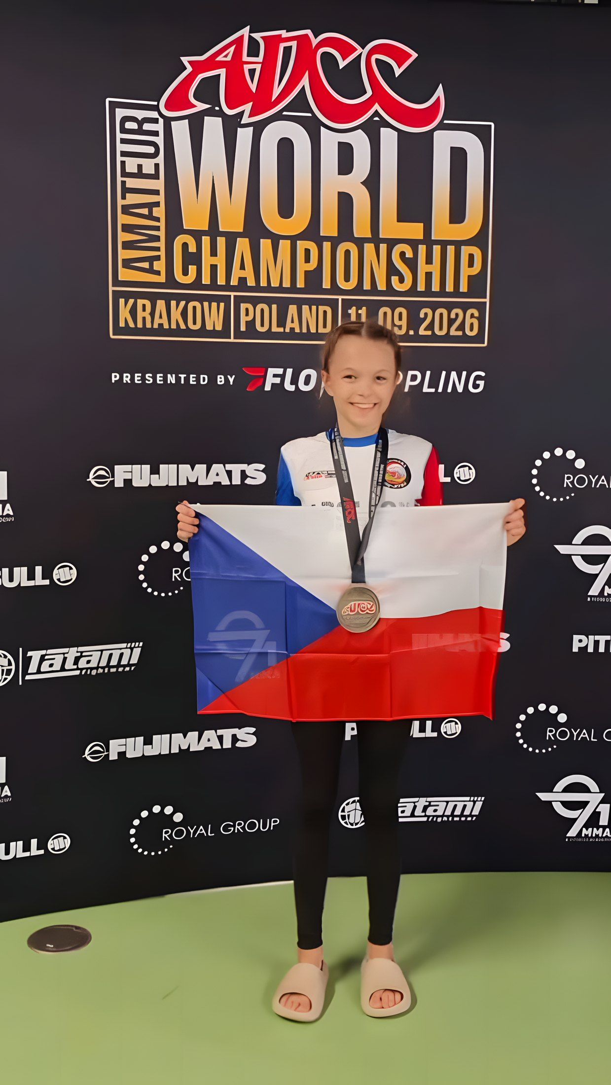 Adéla s bronzovou medailí a českou vlajkou na amatérském mistrovství světa ADCC v Krakově